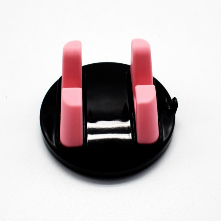 Pink dashboard phone mount with two silicone arms on a black suction base