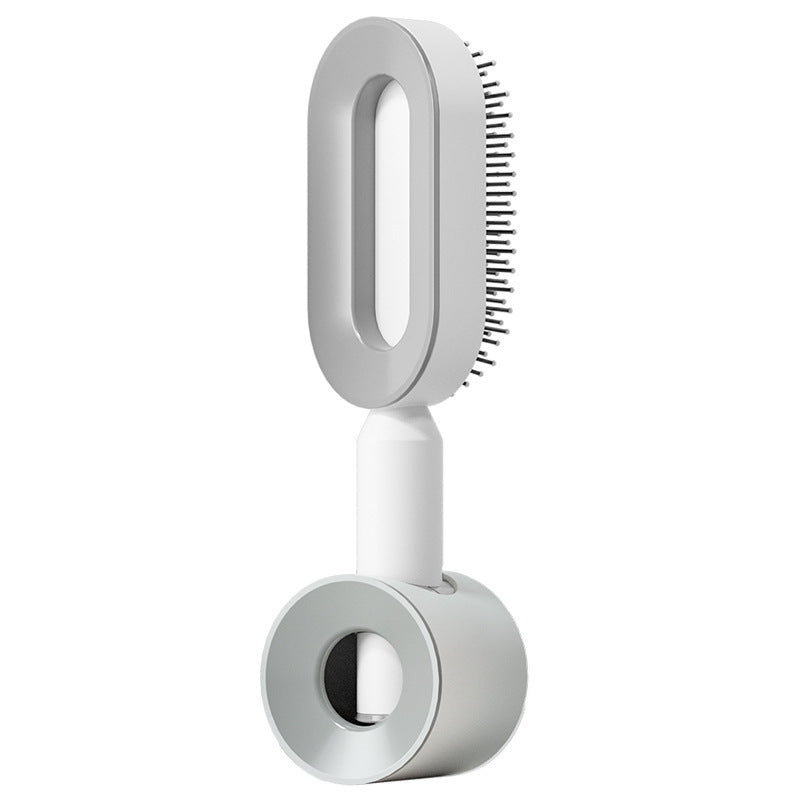 Self-cleaning hair brush with grey bristle head, white handle, and grey cleaning base