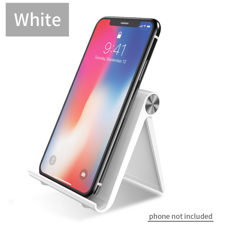 White desktop phone stand with angled legs and circular knob, holding a smartphone