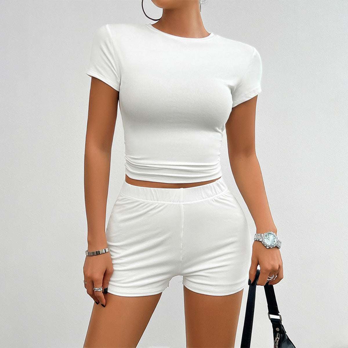 White women's sports set with short-sleeve fitted cropped top and high-waist shorts