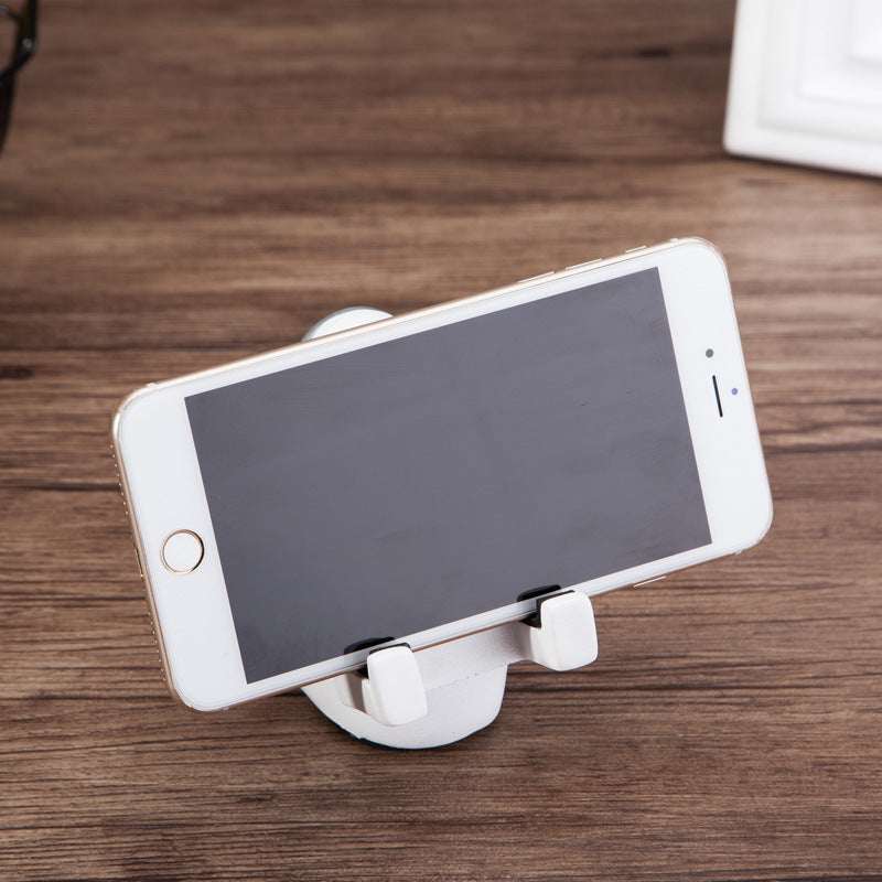 Astronaut phone stand with white base supporting a smartphone in landscape