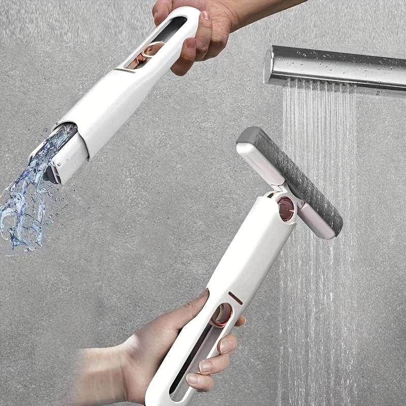Portable self-squeeze mini mop with rectangular head, water streaming from mop opening