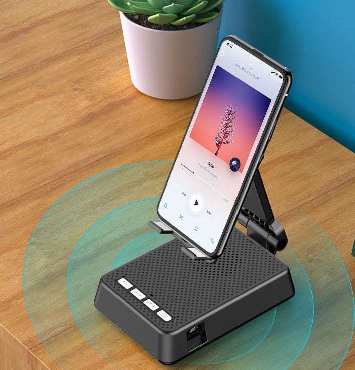 Black phone stand with Bluetooth speaker, tilted cradle on round light ring