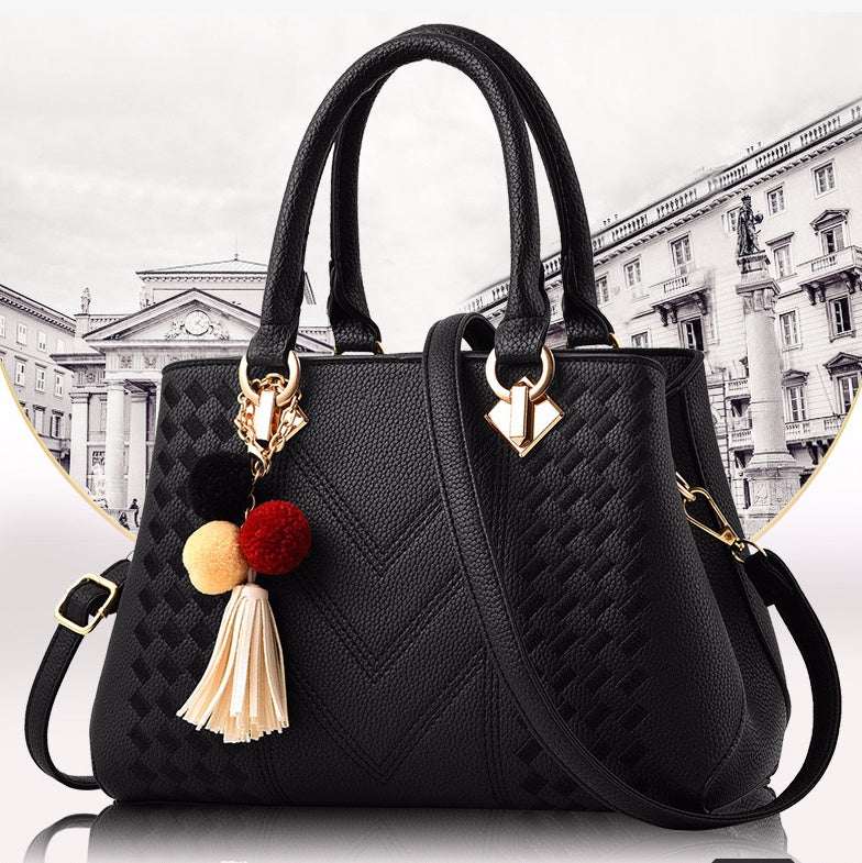 Black quilted crossbody handbag with tassel pom and gold-tone hardware