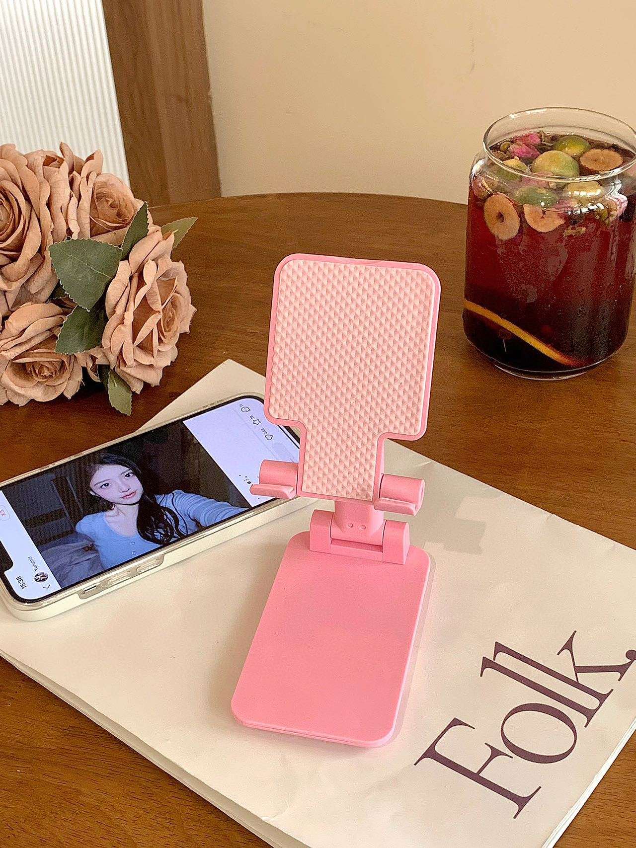 Folding mobile phone stand, pink base with textured back panel and angled support