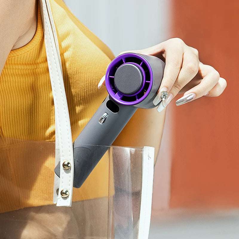 Portable turbo cooling fan with purple-ring grille, held in hand